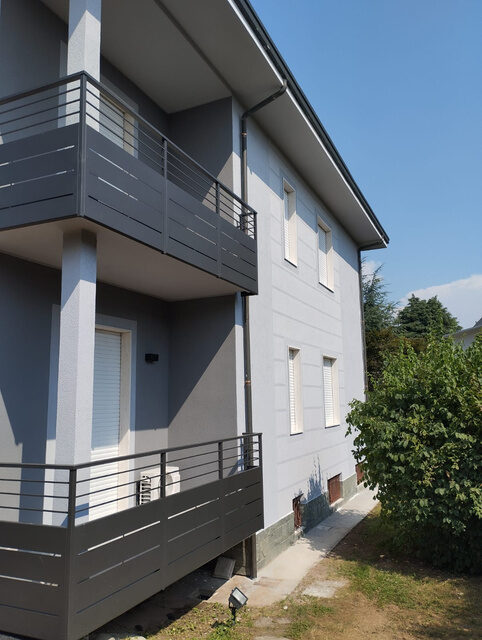 Palazzina con facciata grigia e balconi con parapetti